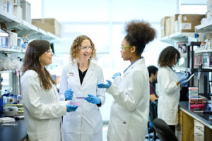 Three clinicians discuss research in lab setting.