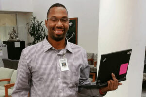 headshot of LaMont Reed, holding a laptop