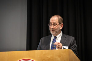 Man in suit speaking at lectern