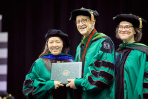 Image of Dean, faculty member and student at commencement