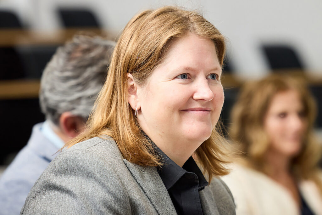 Woman seated in auditorium, smiling