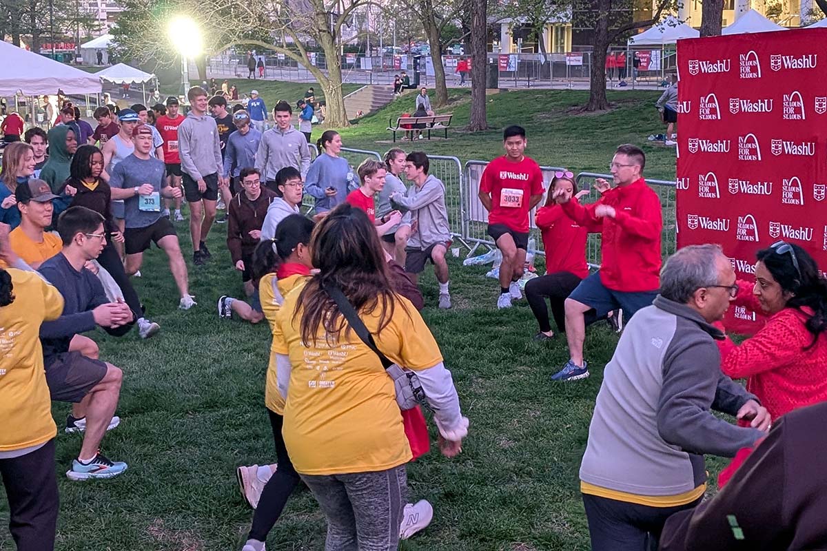 Crowd of ~15 people stretch together in advance of race