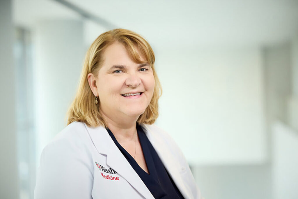 Photo of female physician in white coat, smiling