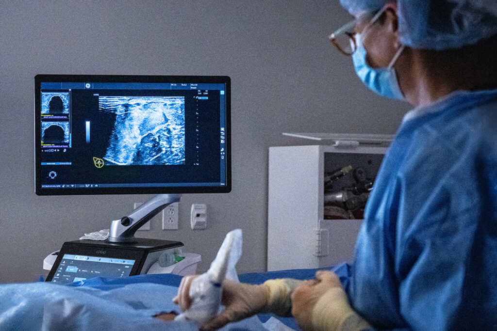 Doctor performing a procedure on a patient in a hospital bed.