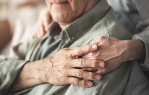 Comforting hand supporting an elderly man