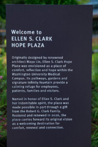 Sign that reads, "Originally designed by renowned architect Maya Lin, Ellen S. Clark Hope Plaza was envisioned as a place of comfort, reflection and hope within the Washington University Medical Campus. Its pathways, gardens and signature infinity fountain provide a calming refuge for employees, patients, families and visitors. Named in honor of Ellen S. Clark and her indomitable spirit, the plaza was made possible in part through a gift from the Robert G. Clark Family. Restored and renewed in 2026, the plaza carries forward its original vision as a welcoming destination for comfort, renewal and connection."