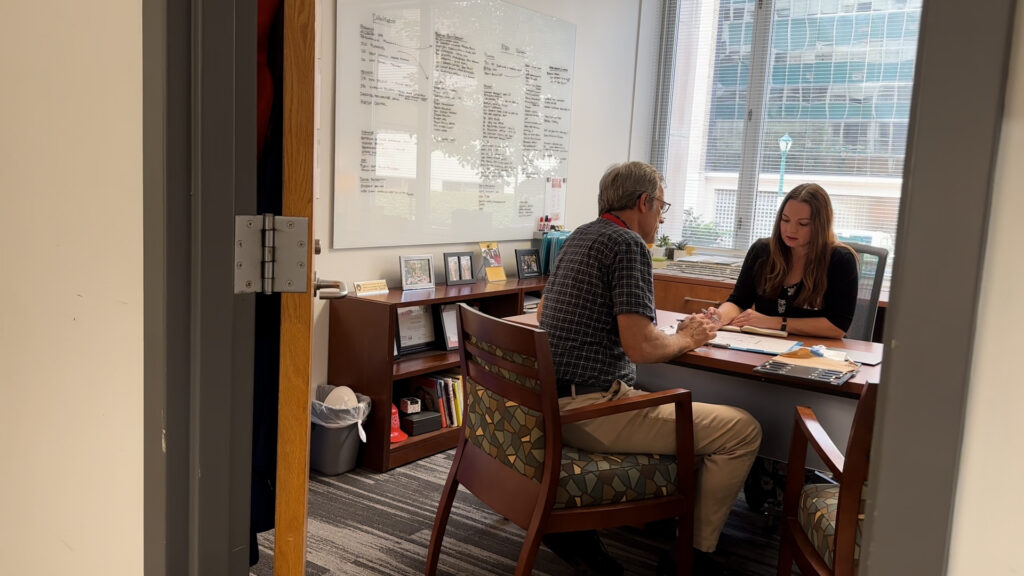 Bob Henkel works with Hannah Jefferies in her office on the WashU Medicine campus.